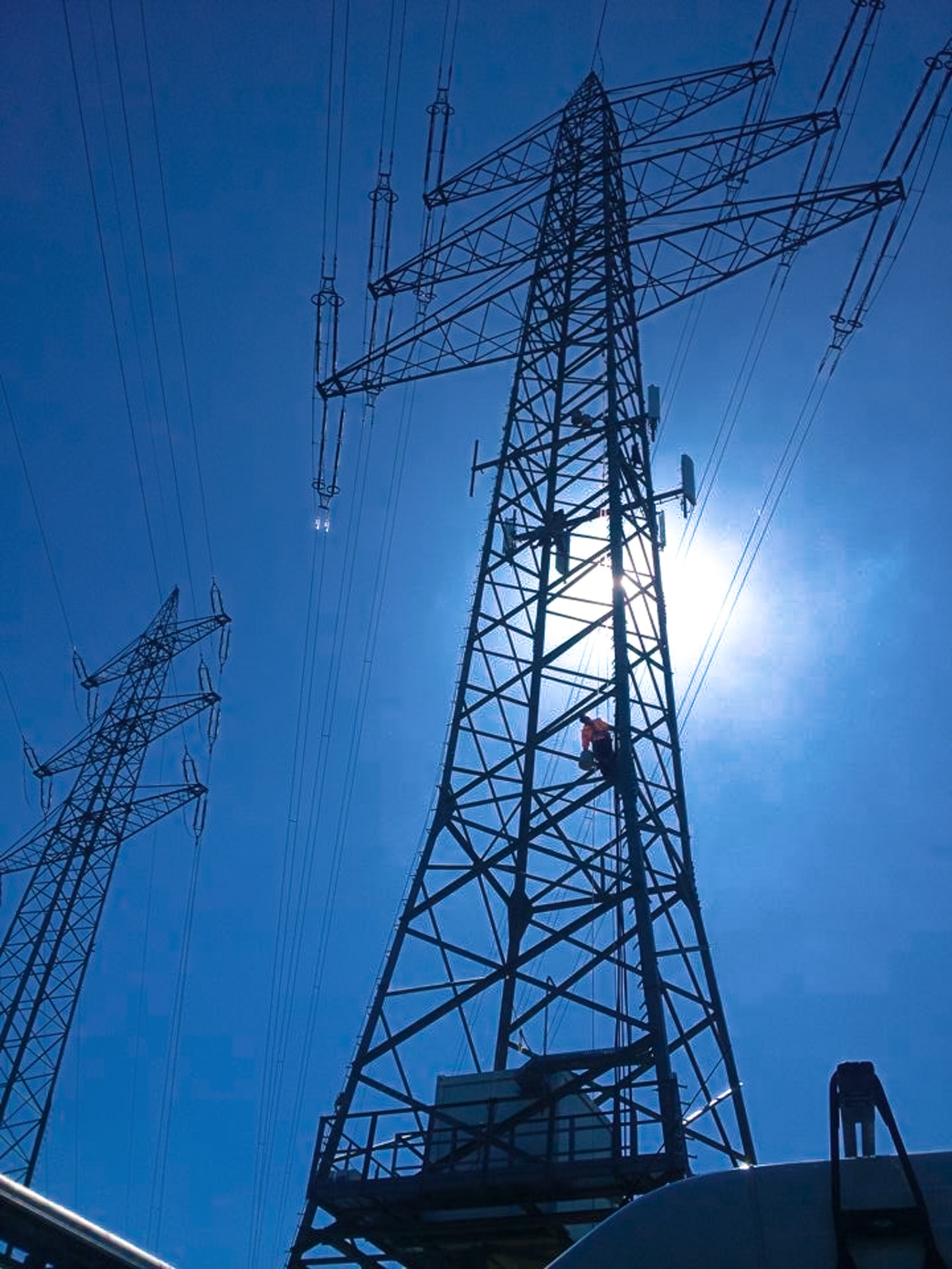 ABEL Antennenanlage an Hochspannungsmasten vor blauem Himmel